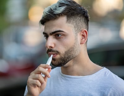 Ein Mann der eine E-Zigarette raucht