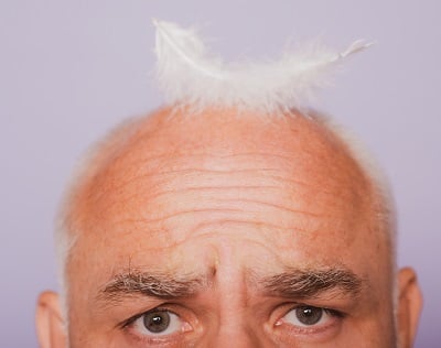 Ein Mann mit Glatze wegen altersbedingtem Haarausfall.