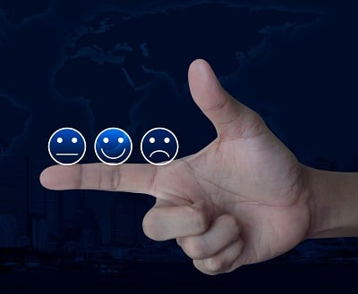 Smiley-Bewertungssymbole auf Finger über Weltkarte