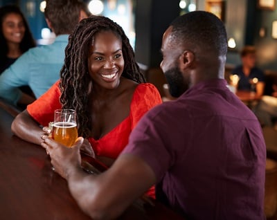 Ein junges Paar in einer romantischen Beziehung trinkt Bier