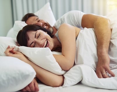 Ein entspanntes junges Paar im Bett nach gutem Sex.