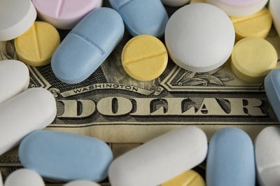 Ein Bild von Pillen und US-Dollars als Anspielung auf den Preis von Medikamenten