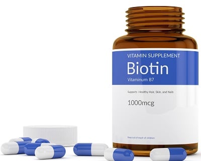 Ein Fläschchen und Kapseln mit Biotin (Vitamin B7)