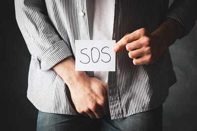 Ein Mann hält die Aufschrift SOS als Hilfebedarf bei einer Geschlechtskrankheit