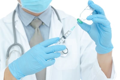 Ein Arzt hält eine Spritze mit einem flüssigen Impfstoff zur Vorbeugung von Geschlechtskrankheiten