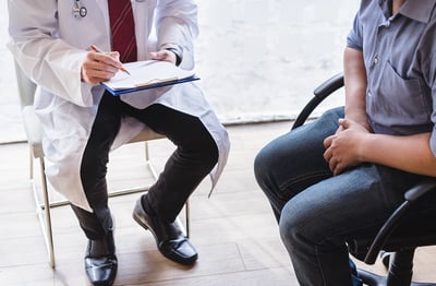 Ein Arzt erklärt einem Mann die Behandlungsmöglichkeiten bei gutartiger Prostatavergrößerung