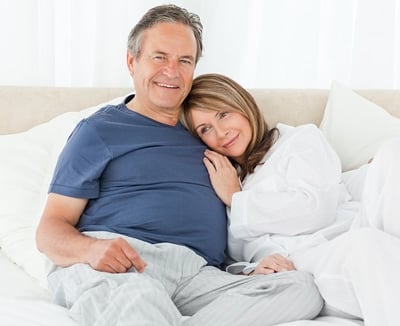 Ein Paar liegt nach einer befriedigenden sexuellen Erfahrung im Bett