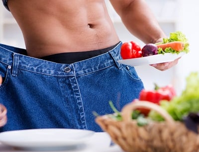  Ein Mann, der durch gesunde Ernährung Gewicht verliert.