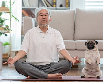 Ein Mann meditiert und praktiziert Yoga zu Hause.