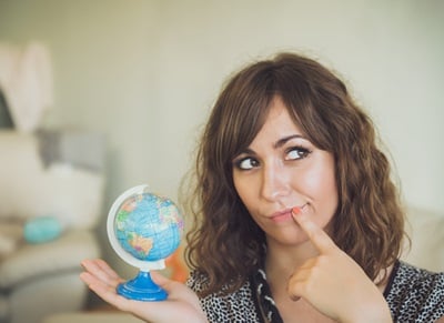 Frau hält kleinen Globus in der Hand, als ob sie eine Reise planen würde