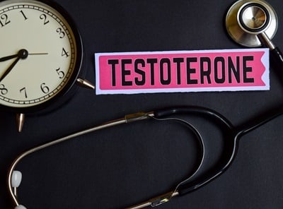 Eine Uhr, ein Pharyngoskop und die Aufschrift „Testosteron“