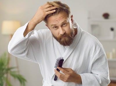 Mann, der sich mit Haarausfallproblemen befasst